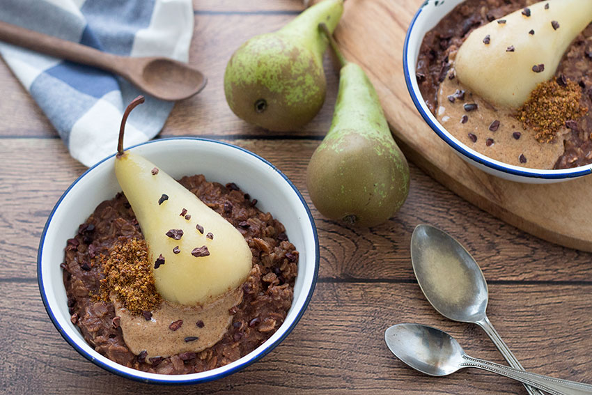 two bowls healthy chocolate porridge with poached pear with Linwoods seeds