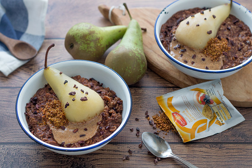 two bowls healthy chocolate porridge with poached pear with Linwoods seeds