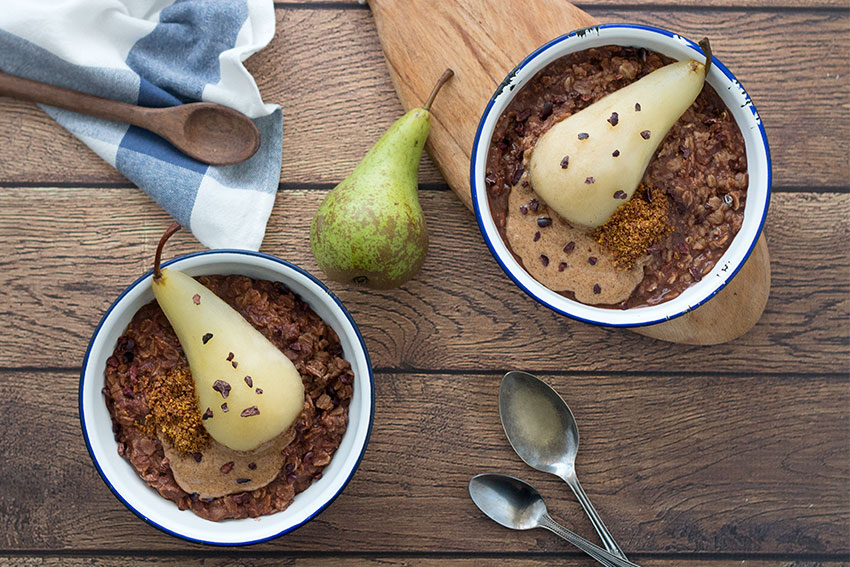 two bowls healthy chocolate porridge with poached pear